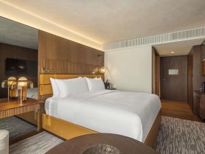 a hotel room with a large bed and a table at Fairmont Golden Prague in Prague