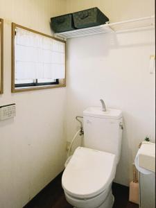 a bathroom with a white toilet and a window at 直島古民家一棟貸し笑くんNaoshima 'Shoukun' Entire house in Naoshima +19 photos