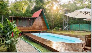 een klein huisje met een zwembad en een parasol bij Aroldo Amazon Lodge in Puerto Maldonado