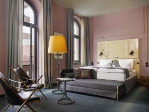 a bedroom with a bed and a chair and a lamp at 25hours Hotel Altes Hafenamt in Hamburg