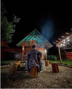 een man in een stoel voor een gebouw bij Aroldo Amazon Lodge in Puerto Maldonado