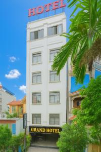 a white hotel with a sign on top of it at Grand Vĩnh Tuy Hanoi Hotel&Spa in Mai Phúc