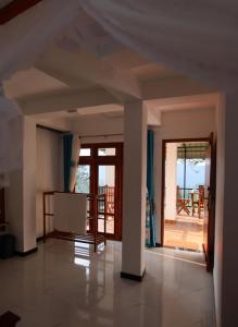 an empty living room with a view of a balcony at Ella Ninestars Lodge in Ella