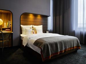 a bedroom with a large bed with a wooden headboard at 25hours Hotel Hamburg HafenCity in Hamburg