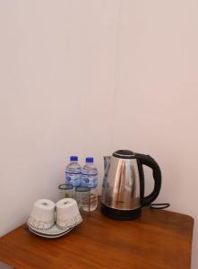 a coffee maker and water bottles on a wooden shelf at Ella Ninestars Lodge in Ella