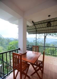 a wooden table and two chairs on a balcony at Ella Ninestars Lodge in Ella +6 photos