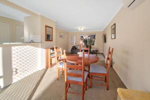 una sala da pranzo e una cucina con tavolo e sedie di Central Escape - Walk to CBD, Cosy & Convenient a Wagga Wagga