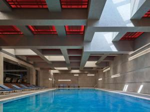 a large swimming pool with blue water in a building at Thompson Shanghai Expo, by Hyatt in Shanghai