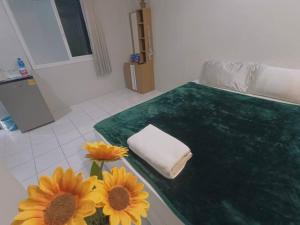 a bedroom with a bed with sunflowers and a towel at Gift house # 5 minutes to Central festival in Hat Yai +57 photos