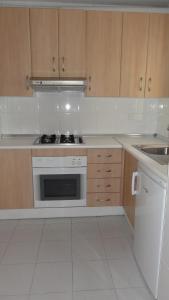 a kitchen with wooden cabinets and a stove top oven at Apartamentos Golf Center in Roquetas de Mar