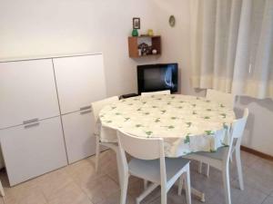 une cuisine avec une table et des chaises et une télévision dans l'établissement Holiday home in Eraclea Mare 25653, à Marina di Santa Croce