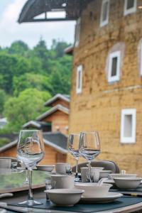 a table with wine glasses and plates on it at Yuntuji Homestay, Yongding Tulou Branch, Longyan in Bajia