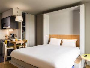 Un dormitorio con una cama grande y una cocina. en Adagio Access Stuttgart Airport Messe, en Leinfelden-Echterdingen