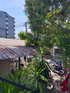 a motorcycle parked next to a building with trees at Gift house # 5 minutes to Central festival in Hat Yai