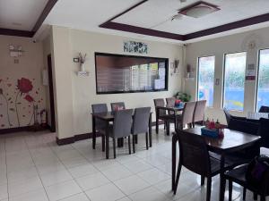 a dining room with tables and chairs and a tv at V.P. GO INN in Solangon