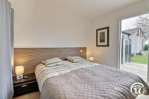 a bedroom with a bed and a large window at Cerillac in Questembert