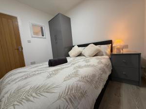 a bedroom with a large bed with a nightstand and a bed sidx sidx sidx at Britlodge Living in Manchester