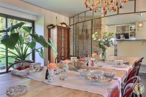 a dining room table with flowers and dishes on it at La metairie in Plédèliac