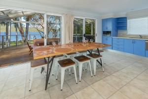 a kitchen with a large wooden table and chairs at Reflections in Smiths Lake