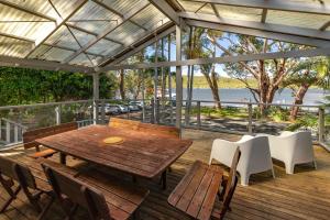 a wooden table and chairs on a deck at Reflections in Smiths Lake