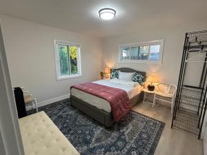 a bedroom with a bed and a chair and windows at Flora in Ontario