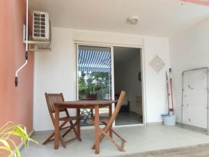 a wooden table and chairs in a room with a window at Kampagn Jacuzzi - Rémire Wifi et climatisation in Bourda