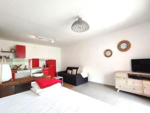 a bedroom with a bed and a couch and a tv at Kampagn Jacuzzi - Rémire Wifi et climatisation in Bourda