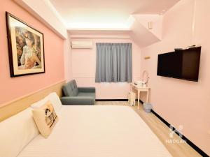 a room with a bed and a tv and a couch at 芳心蘭厝民宿 in Wujie
