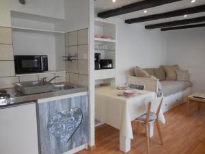 a kitchen and living room with a table and a couch at Gîte Cerise & Coquelicot in Epfig