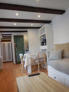 EpfigにあるGîte Cerise & Coquelicotのテーブルとベッド1台付きの部屋、キッチンが備わるアパートメントです。