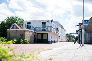 an empty street with a white building with a balcony at HCR Teernstra in Balk