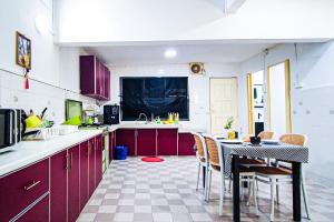 une cuisine avec des armoires rouges et une table et des chaises dans l'établissement Classic Cottage at Sunway by HCK, à Petaling Jaya