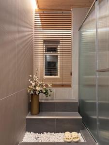 a bathroom with a walk in shower and two pairs of shoes at YeoulHyang, and Dam in Yŏng-do