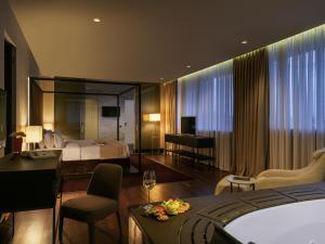 Una habitación de hotel con un dormitorio con una cama y un escritorio. en BERDS Hotel Chisinau - MGallery Collection, en Chişinău 107 fotos más