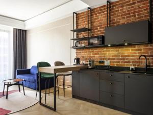 a kitchen with a table and a brick wall at Mercure Krakow Fabryczna City in Kraków +175 photos