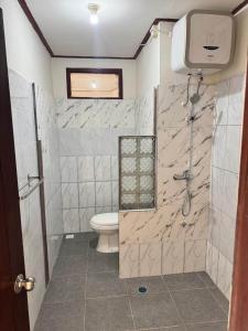 ein Badezimmer mit Dusche und Toilette in der Unterkunft Warmadewa 7, Sanur Guesthouse near beach in Sanur