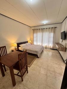 ein Schlafzimmer mit einem Bett und einem Tisch und Stühlen in der Unterkunft Warmadewa 7, Sanur Guesthouse near beach in Sanur