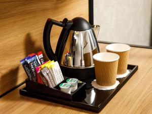 a tea pot and two cups of coffee on a tray at ibis London Sutton Point in Sutton