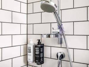 a shower head and a blow dryer in a bathroom at ibis London Sutton Point in Sutton +82 photos
