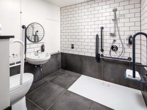 a bathroom with a toilet and a sink at ibis London Sutton Point in Sutton +78 photos