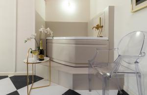a bathroom with a tub and a glass chair at TEATRUM LOFT Teatro Galli -Jacuzzi in camera in Rimini