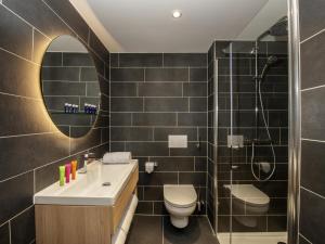 苏黎世Aparthotel Adagio Zurich City Center的带水槽、马桶和镜子的浴室