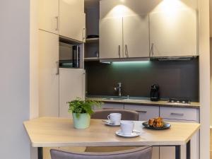 苏黎世Aparthotel Adagio Zurich City Center的厨房里有一张木桌，桌上放着两个咖啡杯。