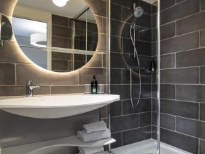 a bathroom with a sink and a shower at Aparthotel Adagio Paris Suresnes Longchamp in Suresnes