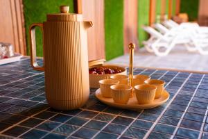 ニズワにあるDarunique Innのテーブルの上に置かれたカップの皿と水差し