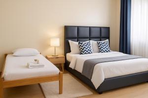 a bedroom with two beds and a lamp on a table at Noaz Hotel in Bulambiro