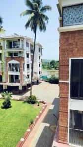 a palm tree in front of a building at Candolim Sea Breez in Candolim