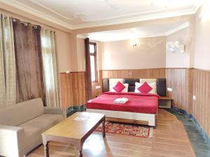 a hotel room with a bed and a couch at Varuni Gd Hotel Mcleodganj in McLeod Ganj