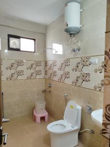 un baño con inodoro y lavabo en Varuni Gd Hotel Mcleodganj, en McLeod Ganj