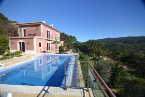 a villa with a swimming pool in front of a house at Villa Vida Nova in Monchique